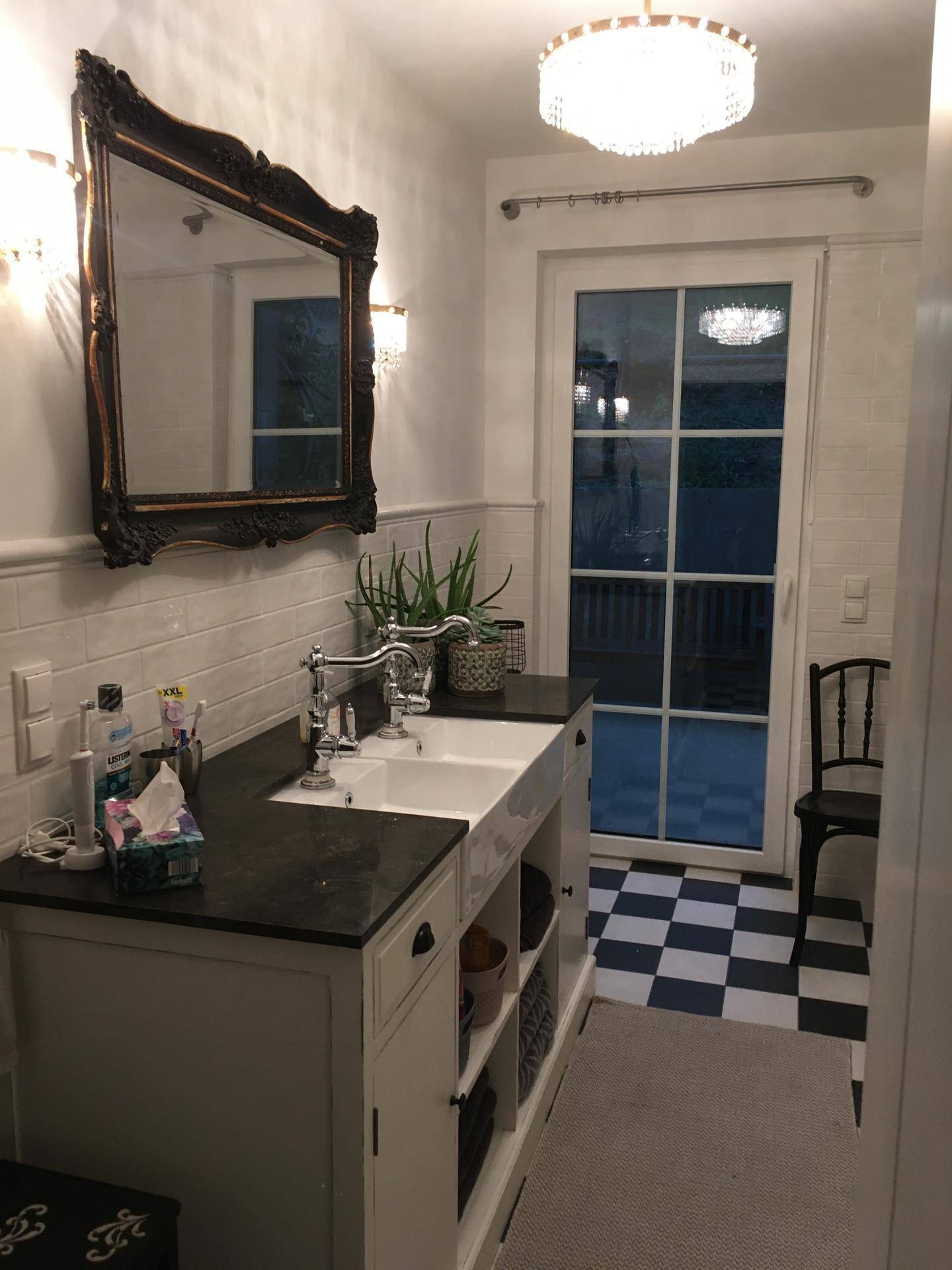 Badezimmer mit Doppelwaschbecken, großem Spiegel und Zugang zu einem Balkon oder Terrasse.
