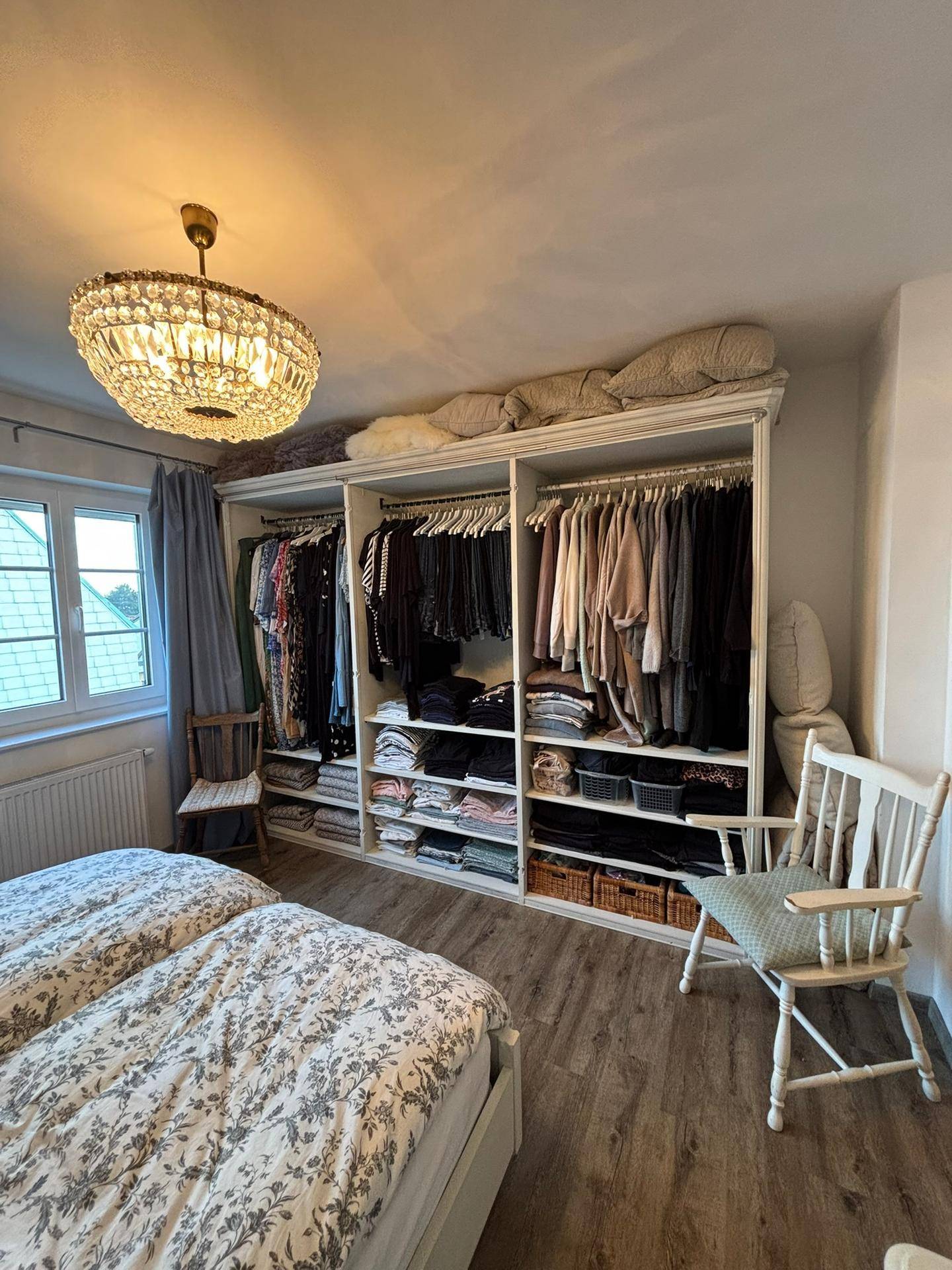 Schlafzimmer mit großem Einbauschrank, Doppelbett und Fenster mit Blick nach draußen.