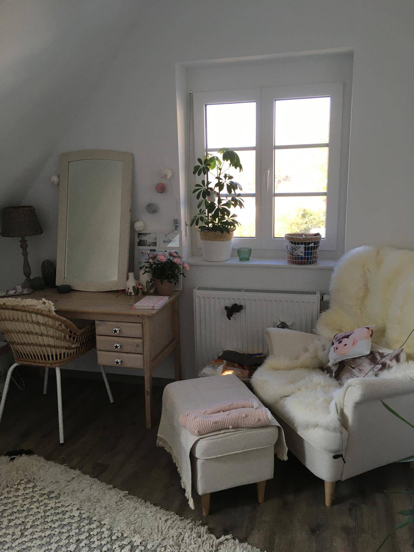 Helles Schlafzimmer mit Schreibtisch, Sessel und großem Fenster für viel Tageslicht.