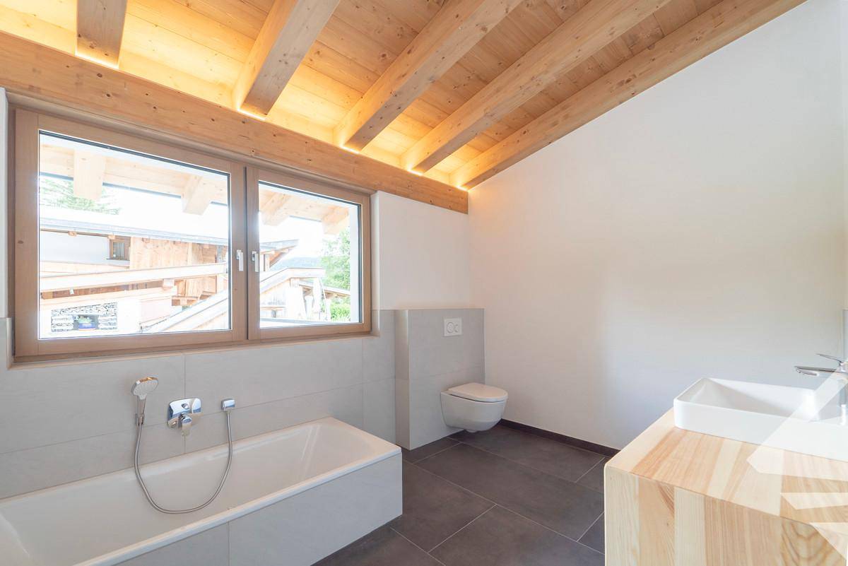 Badezimmer mit Wanne, WC, Waschtisch in Vollholz und Fenster