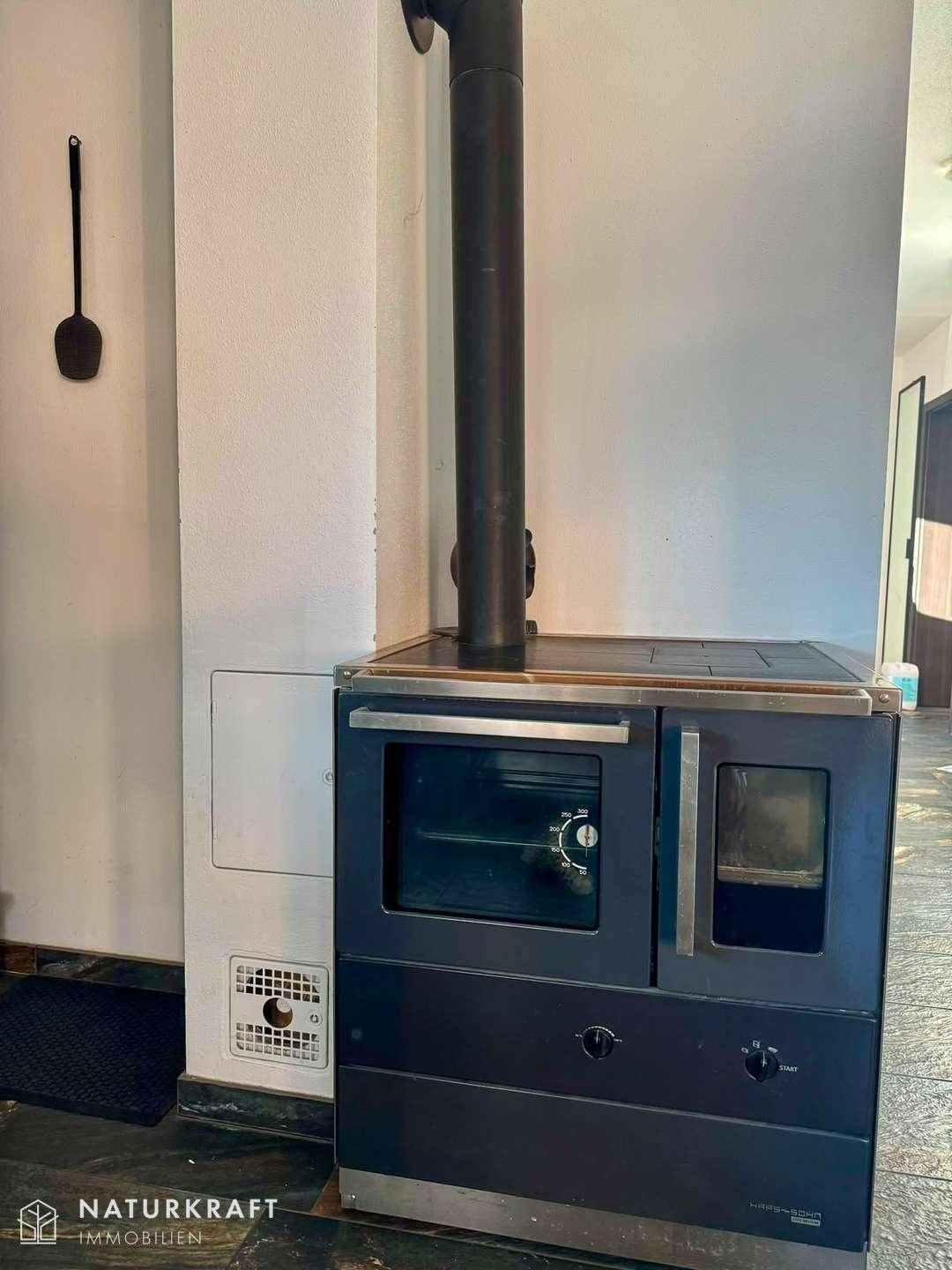 Traditioneller Holzofen mit integriertem Backfach, sorgt für gemütliche Wärme.