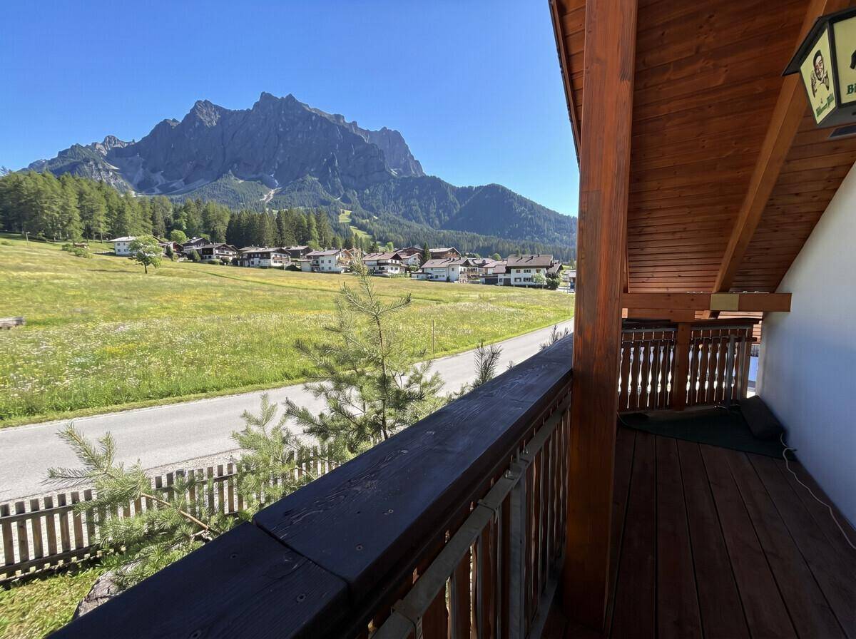 Traditioneller Holzbalkon mit Blick auf die umliegende Natur und die majestätischen Berge.