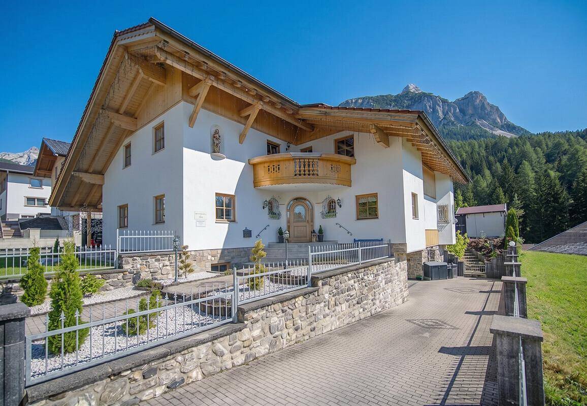 Charmantes alpines Haus mit Holzbalkonen und gepflegtem Vorgarten in sonniger Lage.