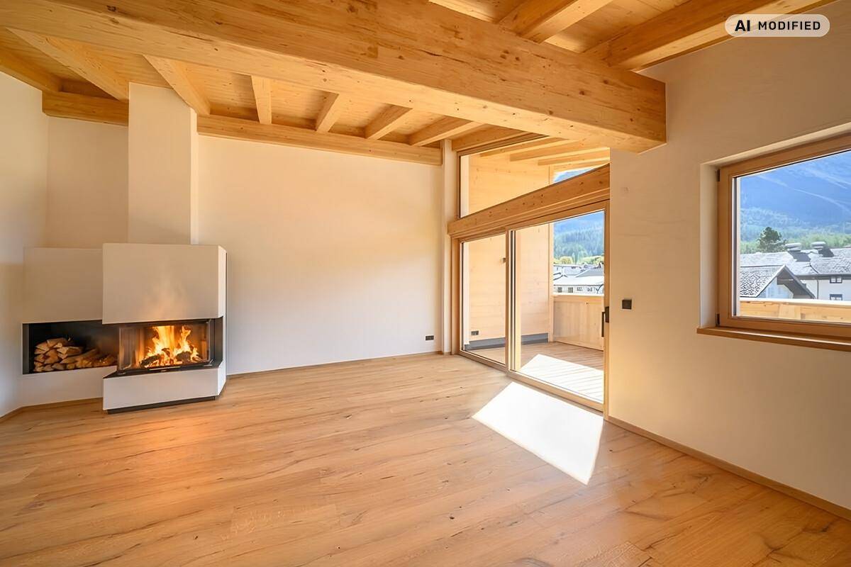 Helles Wohnzimmer mit Holzbalkendecke, modernem Kamin und Zugang zu einem sonnigen Balkon.