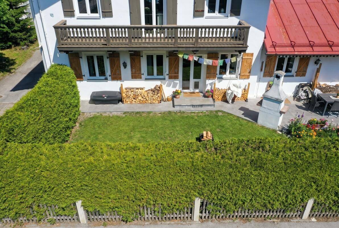 Gepflegter Vorgarten mit Rasenfläche, hoher Hecke und Zugang zum Haus, ideal für Erholung im Freien.