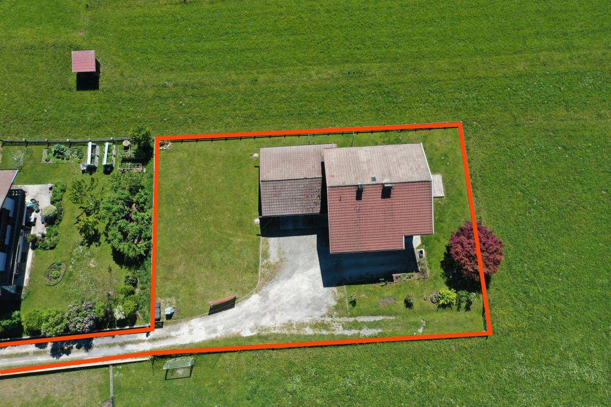 Luftaufnahme des umgrenzten Grundstücks mit Haus, Nebengebäude und Gartenfläche.