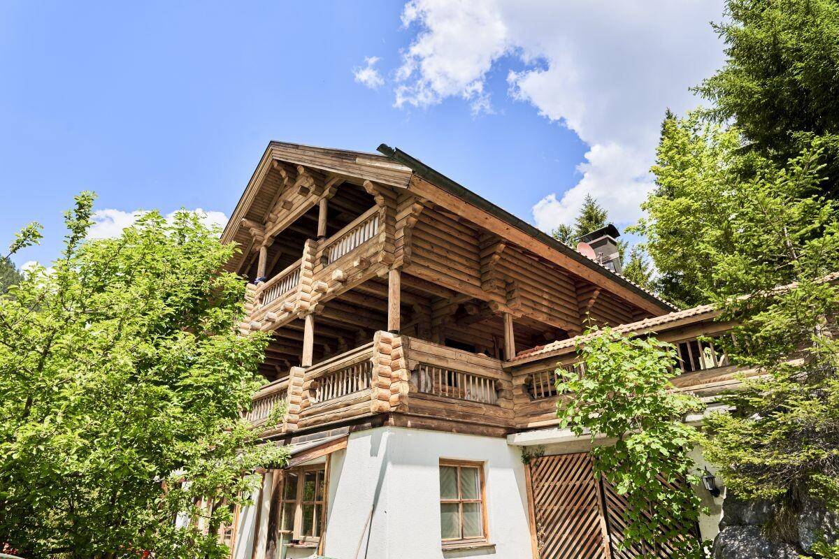 Detailansicht des traditionellen Holzhauses mit kunstvollen Balkonen und rustikalen Holzbalken.