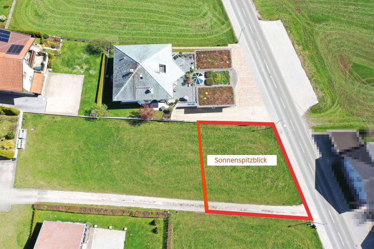 Luftaufnahme eines Hauses mit angrenzendem Grundstück, das mit einem roten Rahmen markiert ist.