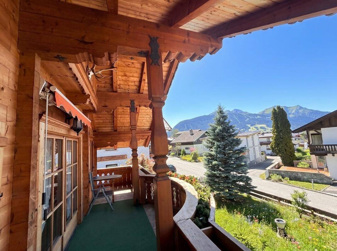 Geräumiger Holzbalkon mit Sitzgelegenheiten und Panoramablick auf die Berglandschaft.
