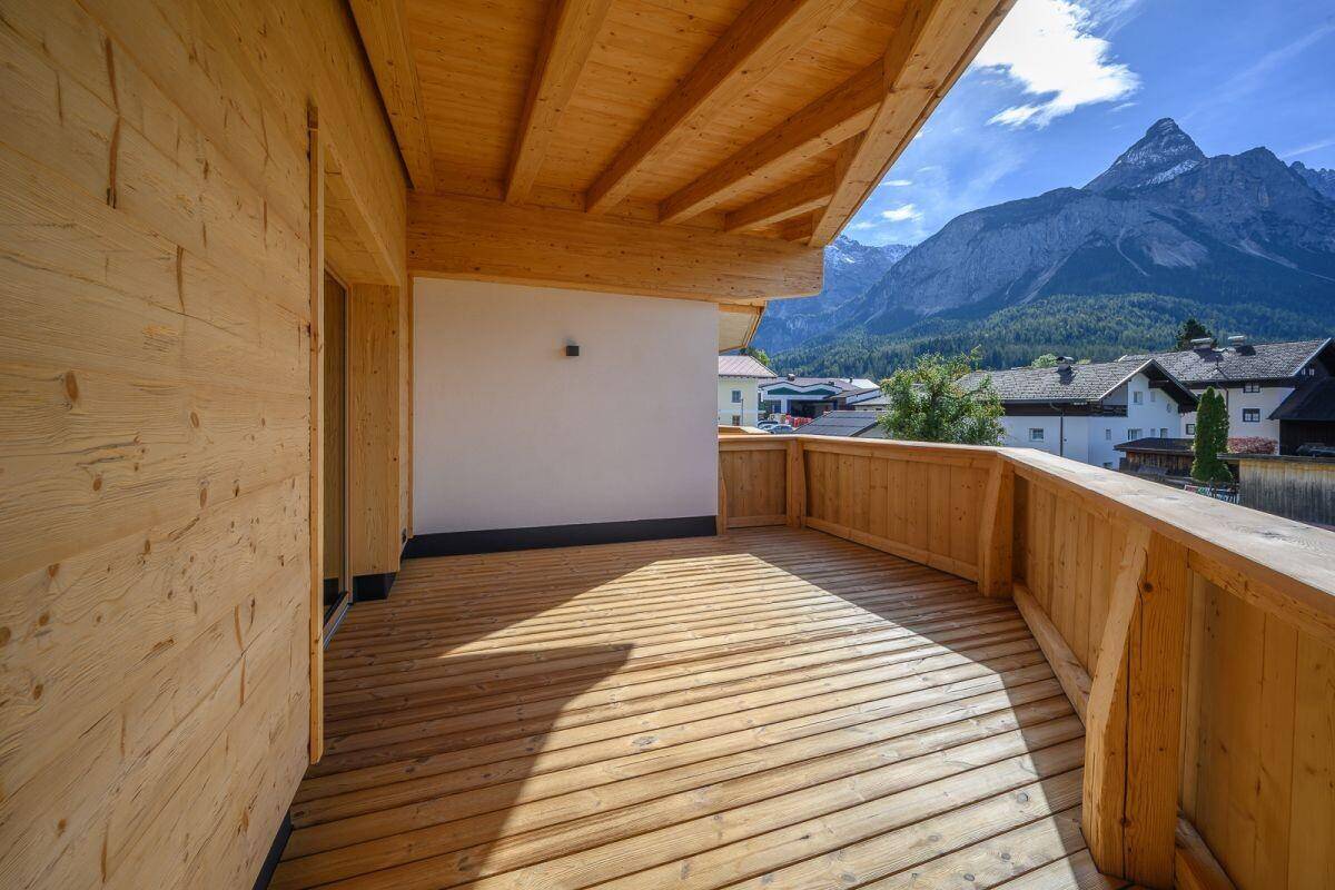 Breiter Holzbalkon mit Bergblick und viel Platz für Outdoor-Möbel.