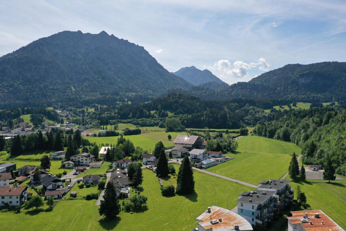 Malerische Luftaufnahme der bergigen Landschaft mit grünen Wiesen und Häusern.