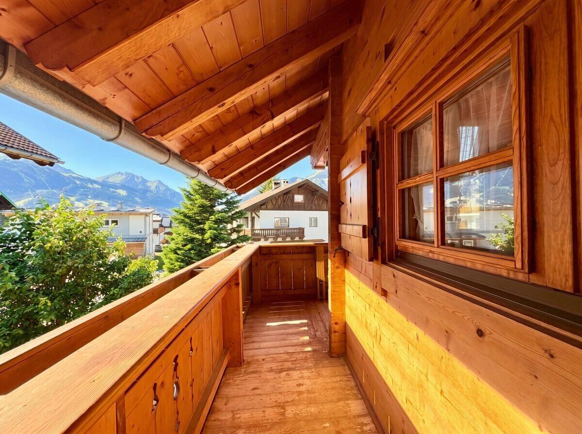 Schmaler Holzbalkon mit rustikalem Charme und weitem Blick auf die umliegenden Berge.