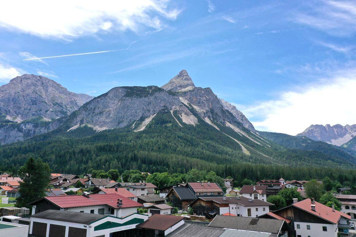 Panoramablick auf eine malerische Berglandschaft mit einem Dorf im Tal.