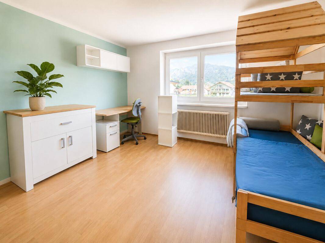 Kinderzimmer mit Etagenbett, Schreibtisch und Blick auf die Berge.