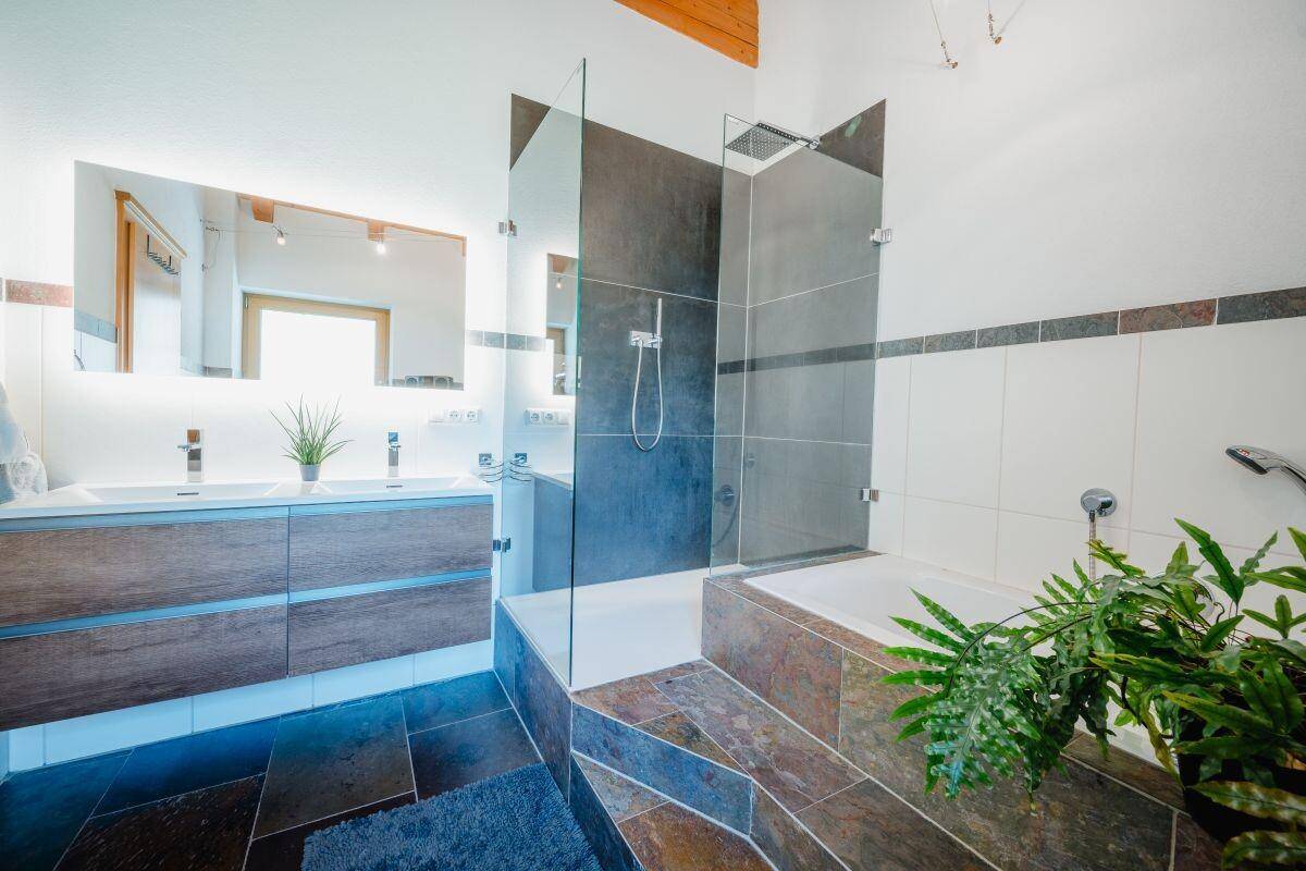 Modernes Badezimmer mit Doppelwaschbecken, begehbarer Dusche und Badewanne.
