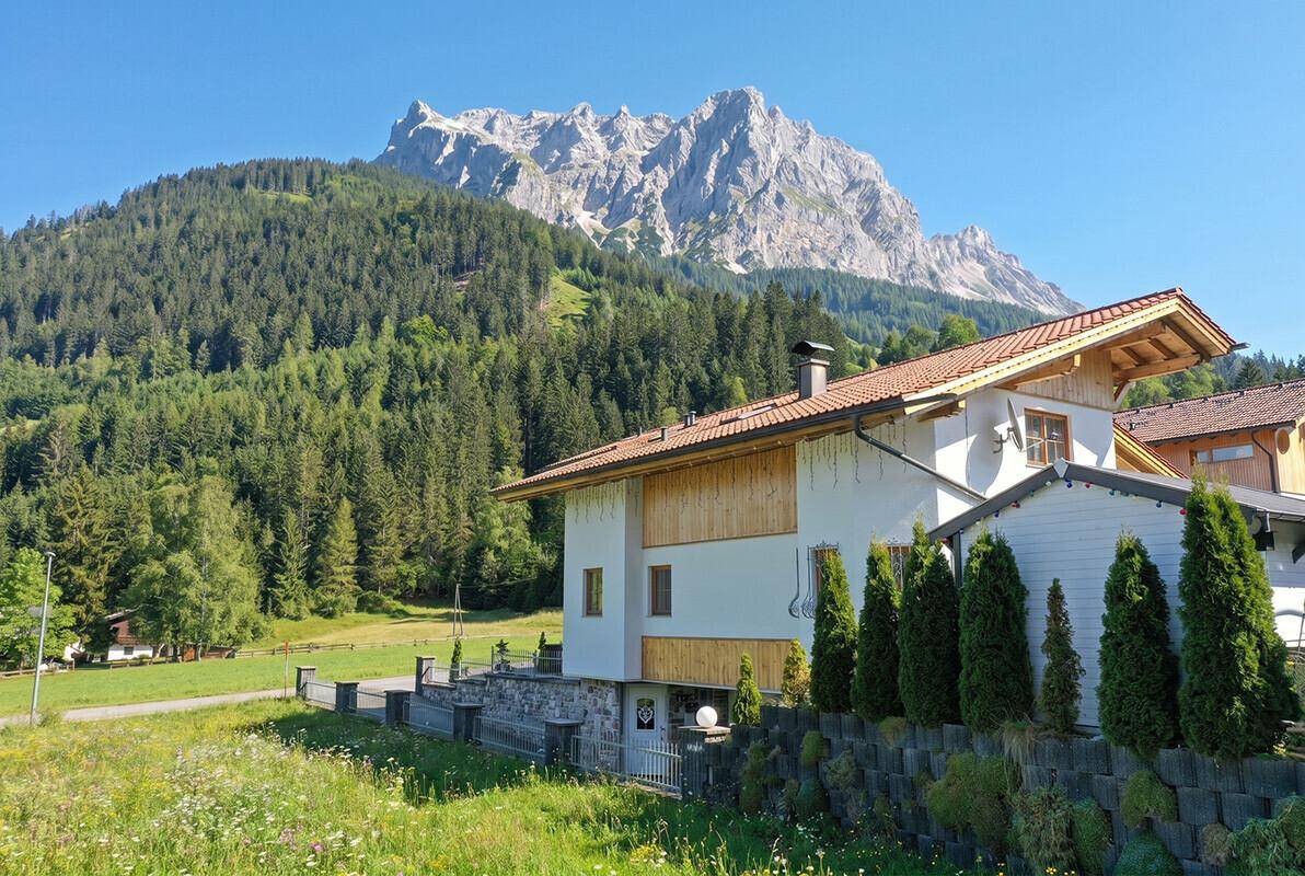 Seitenansicht des Hauses mit traditioneller Architektur und beeindruckendem Bergblick.