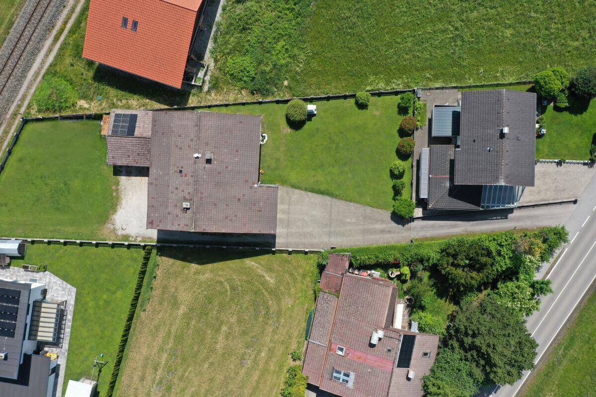Luftaufnahme des Grundstücks mit Haus, Garten und angrenzender Straße.