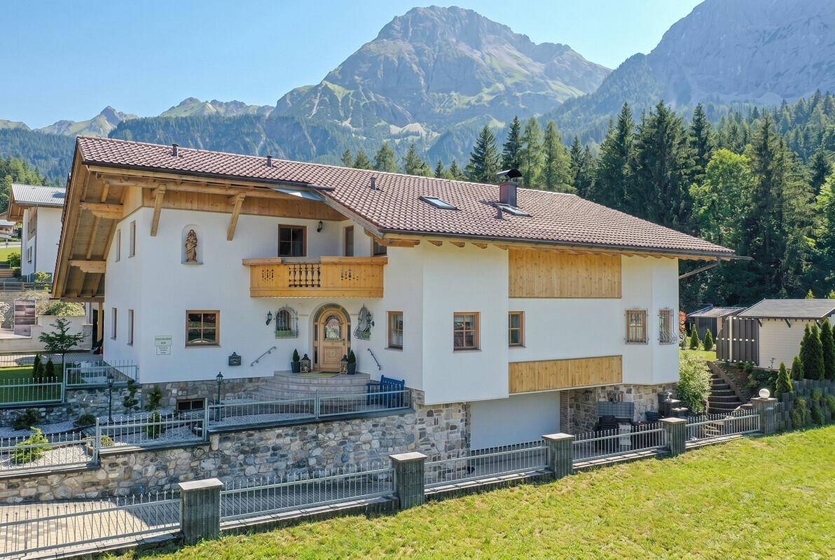 Großzügiges Haus im alpinen Stil mit Bergblick und integrierter Garage.