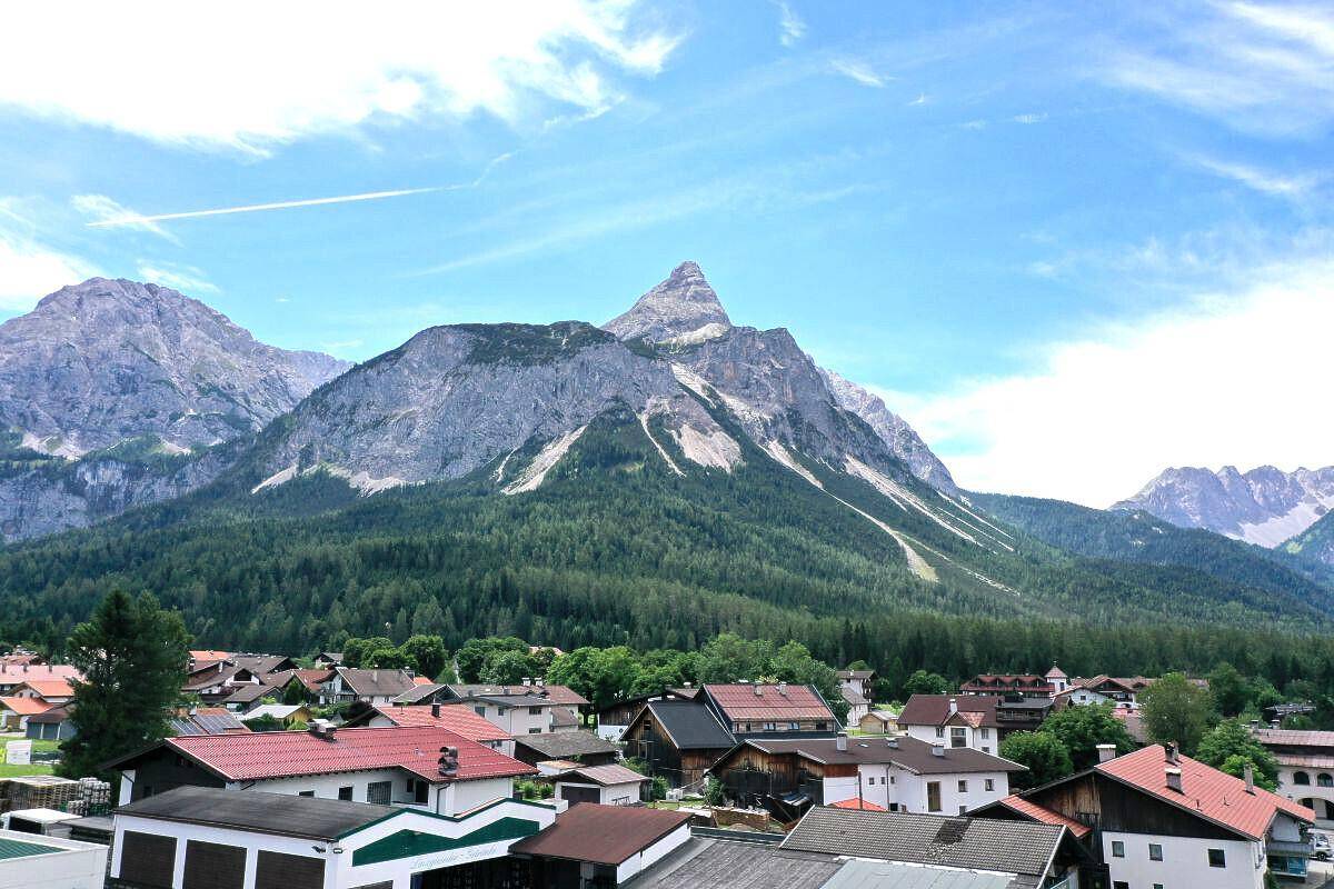 Malerische Berglandschaft mit traditionellen Häusern und weitem Blick auf die umliegende Natur.