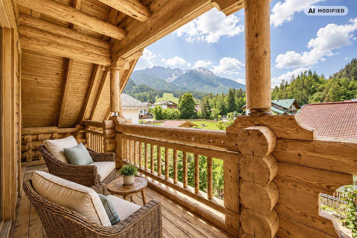 Gemütlicher Balkon mit Korbsesseln und atemberaubendem Blick auf die umliegende Berglandschaft.