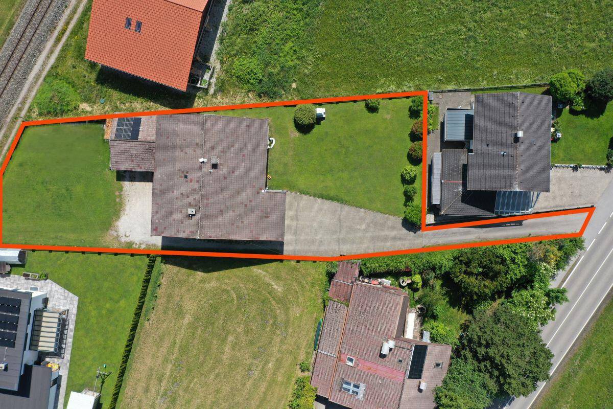 Luftaufnahme des Grundstücks mit markierter Grenze, Haus und umliegender Bebauung.