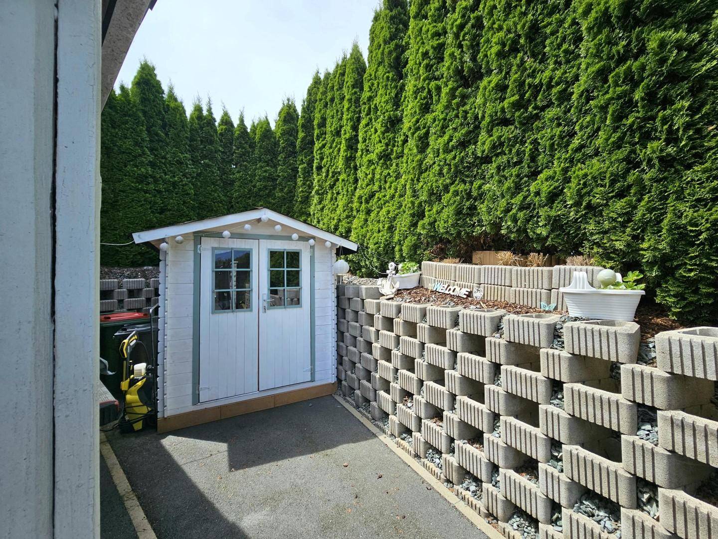 Gartenhäuschen und Müllplatz hinter d. Carport