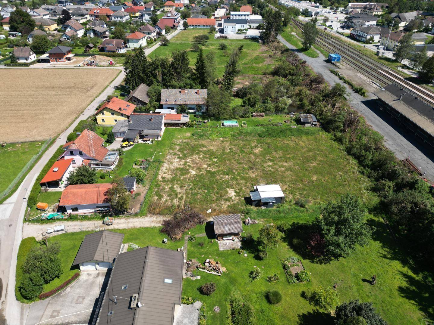 Luftaufnahme des Grundstücks, umgeben von Wohnhäusern und den nahegelegenen Bahngleisen.
