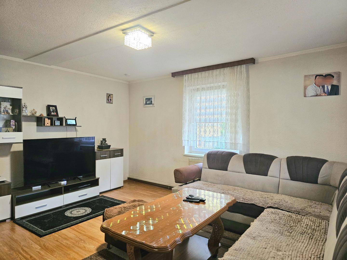 Wohnzimmer mit bequemer Eckcouch, Couchtisch und großem Fernseher für Unterhaltung.