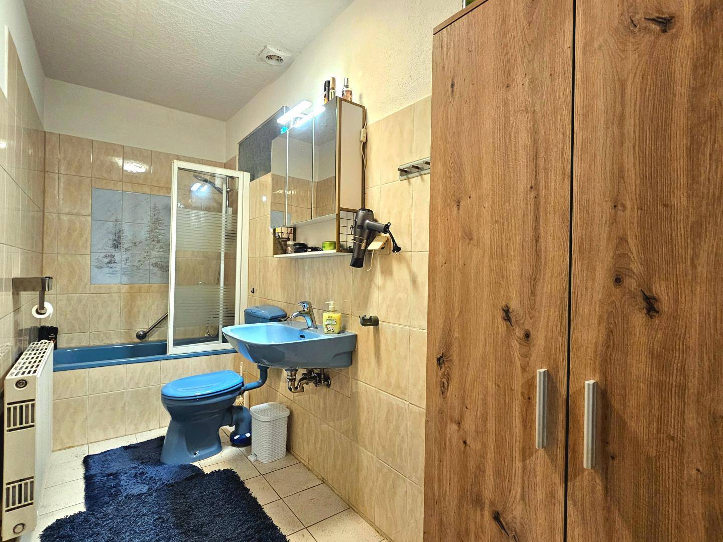 Badezimmer mit Badewanne, Dusche und Waschbecken in traditionellem Design.