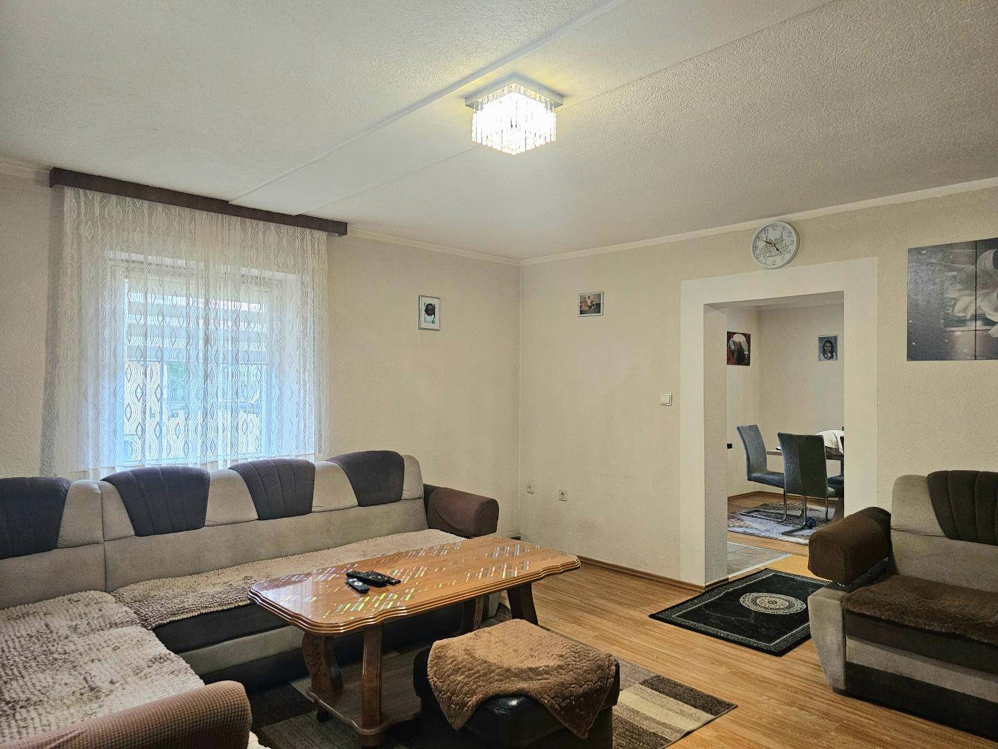 Helles Wohnzimmer mit bequemer Sitzgelegenheit und offenem Zugang zum Essbereich.
