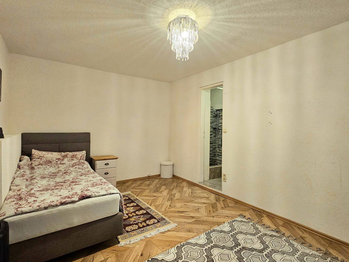 Schlafzimmer mit Einzelbett und direktem Zugang zu einem angrenzenden Badezimmer.