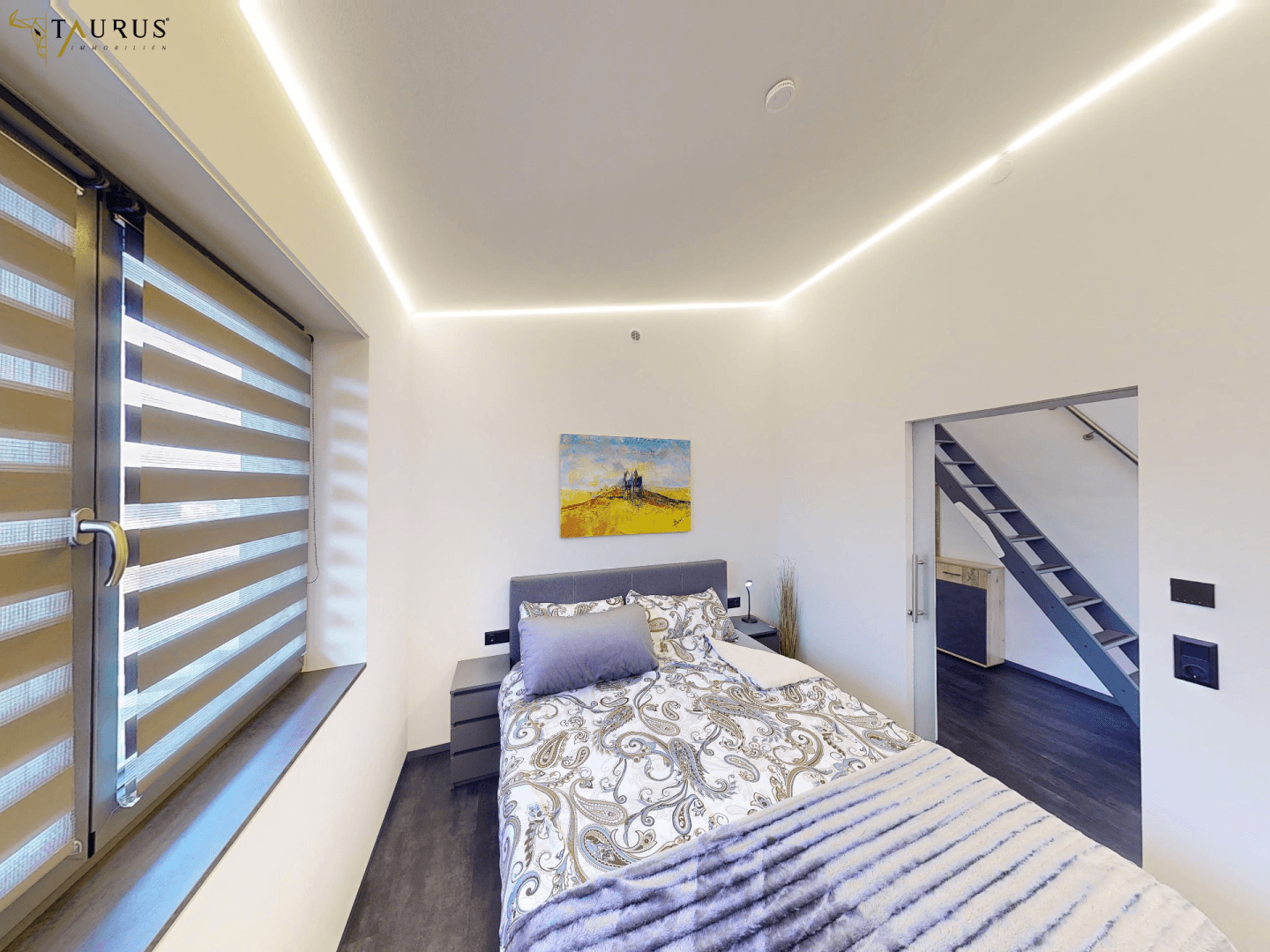 Helles Schlafzimmer mit Doppelbett, indirekter Beleuchtung und Blick auf die Umgebung.