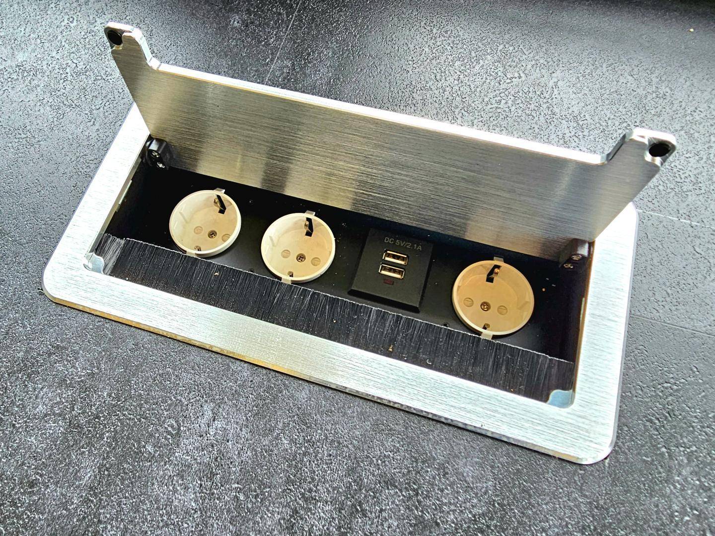 Integrierte Steckdosenleiste mit USB-Anschlüssen in einer modernen Oberfläche.