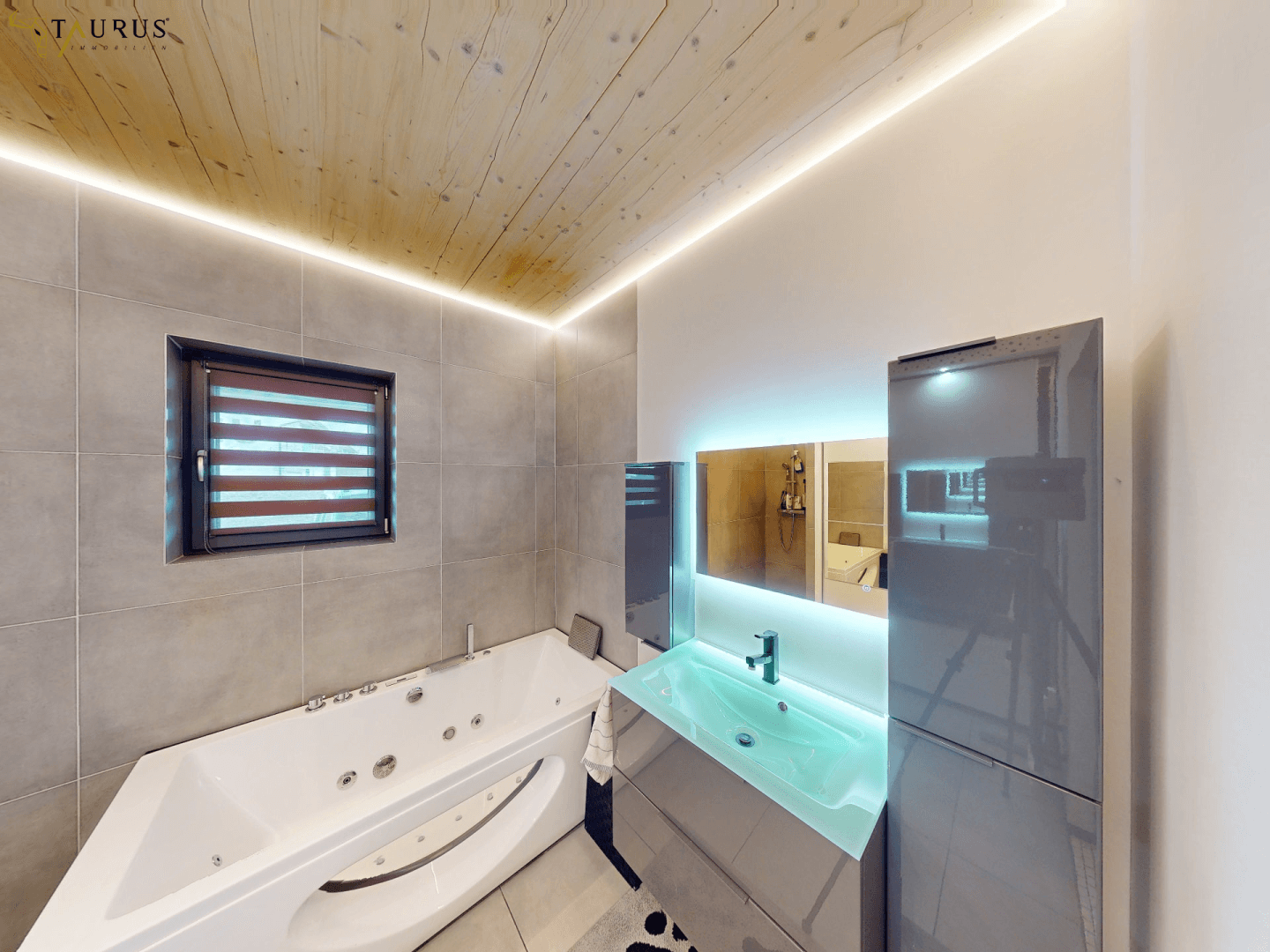 Elegantes Badezimmer mit Whirlpool-Badewanne, modernem Waschtisch und Fenster.