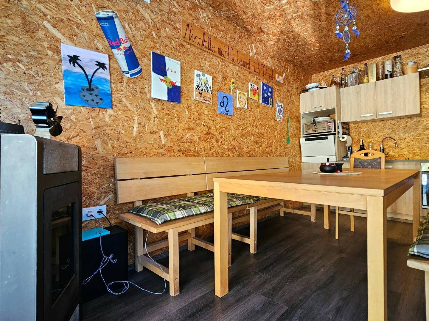 Rustikaler Essbereich mit kleiner Küchenzeile und Holzwänden im Nebengebäude.
