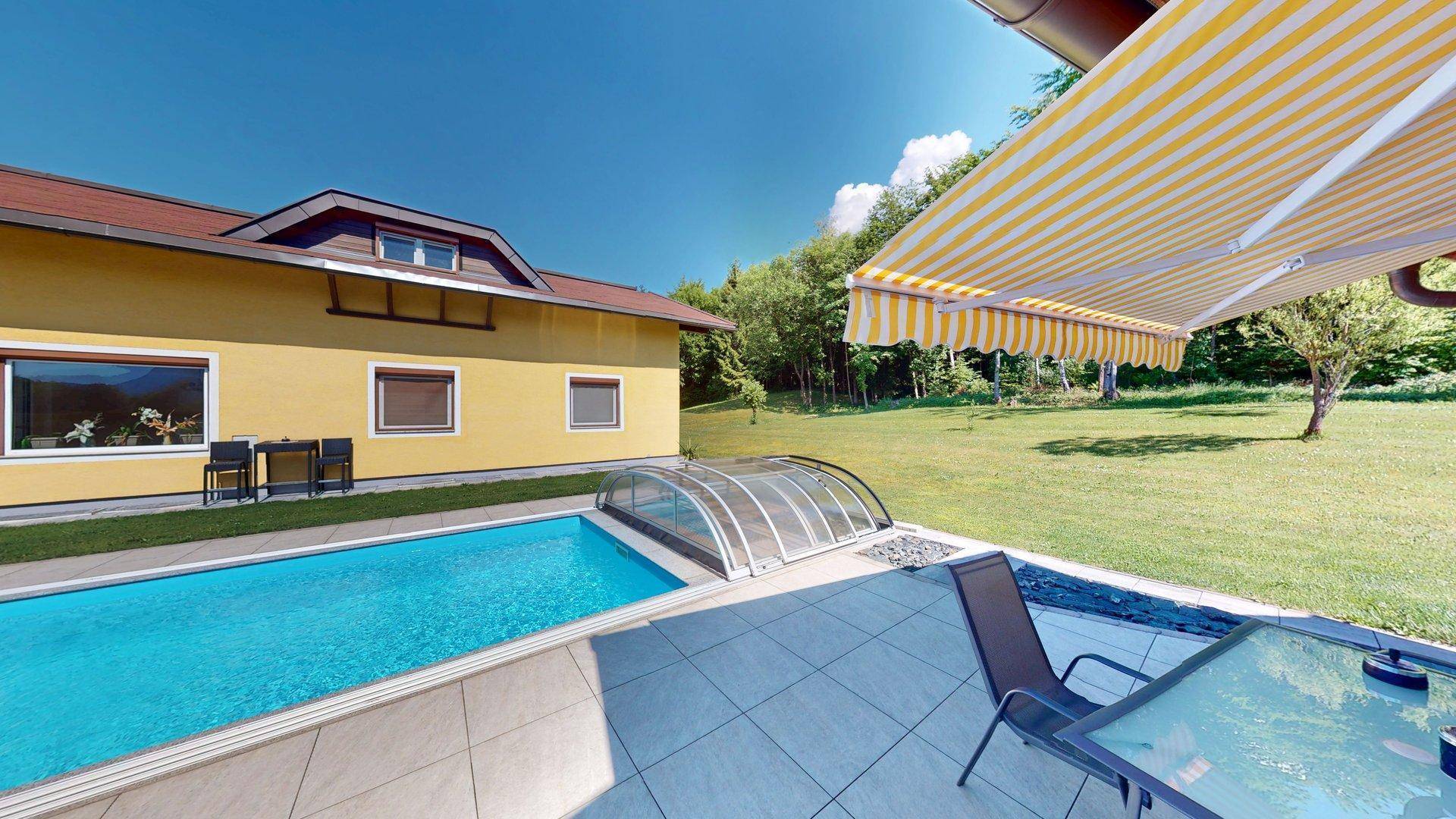 Gemütliche Terrasse mit ausfahrbarer Markise, Sitzgelegenheiten und direktem Zugang zum Pool.