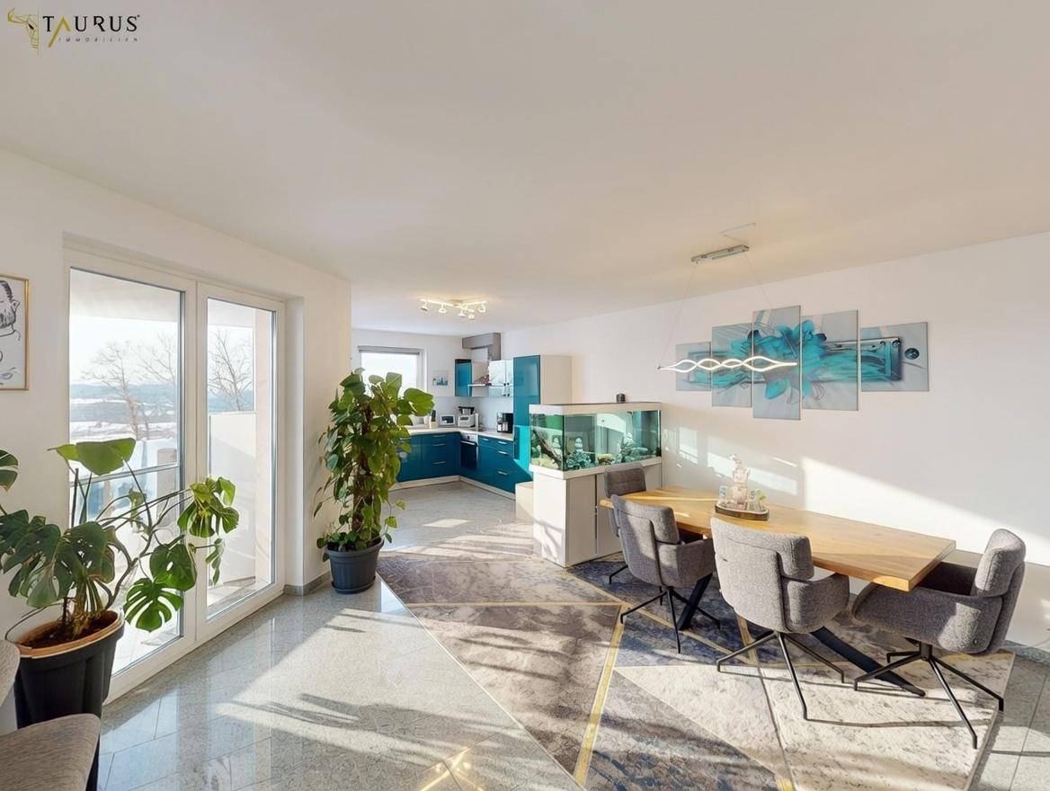 Offener Wohn-Essbereich mit moderner Einrichtung, Granitboden und Zugang zum Balkon.
