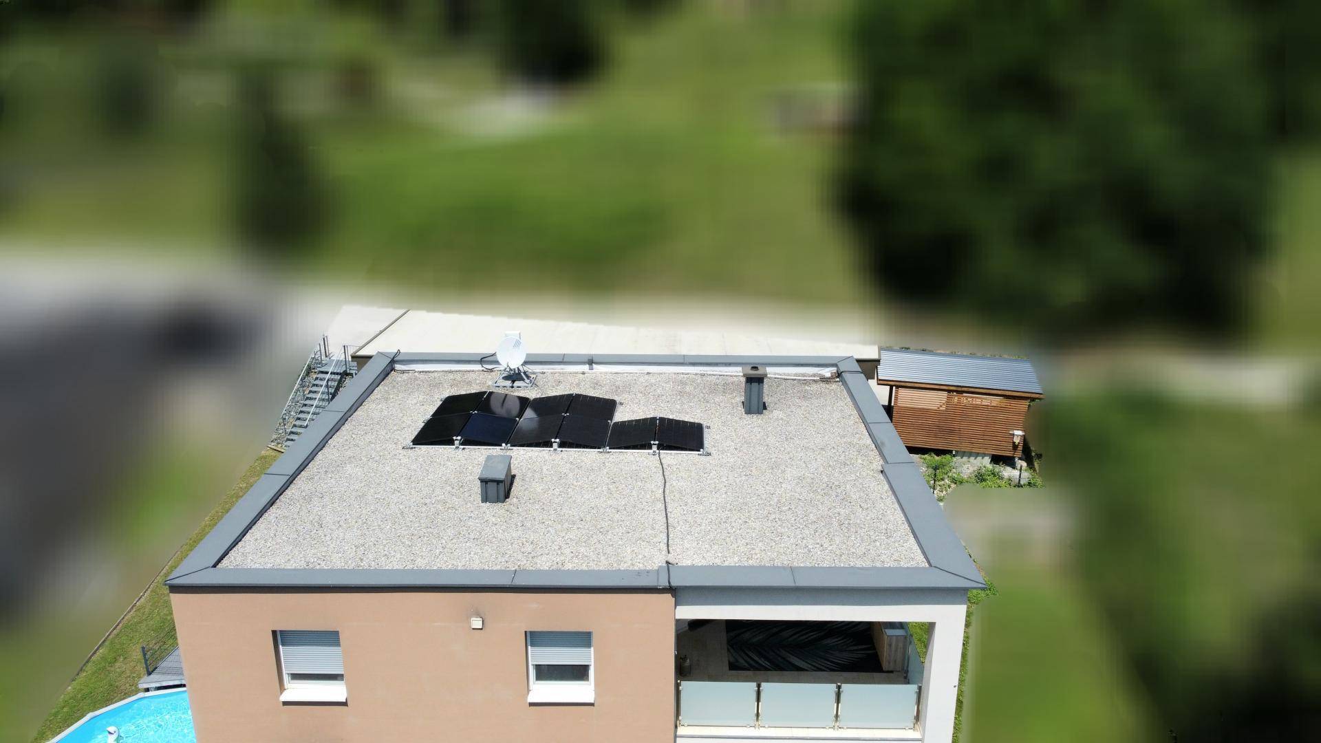 Dachansicht des Gebäudes mit Solaranlage und Zugangstreppe zu einem Nebengebäude.