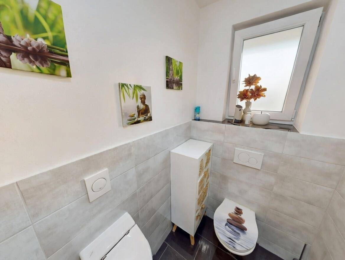 Modernes Gäste-WC mit Fenster, Wand-WC und stilvoller Dekoration.