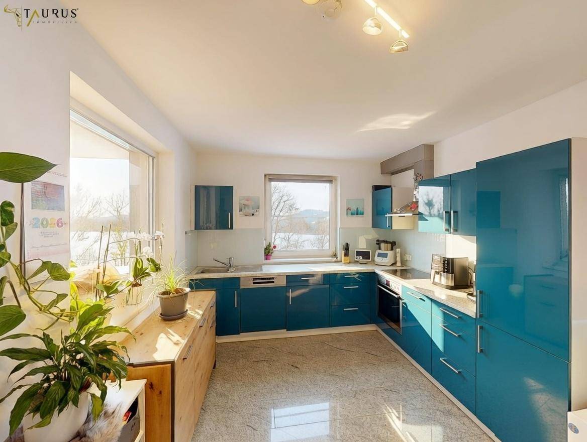 Moderne Küche in Türkis mit Einbaugeräten, Granit-Arbeitsplatten und Fenster.