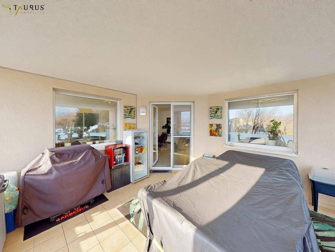 Überdachter Balkon mit Grillbereich und Blick auf die winterliche Landschaft.