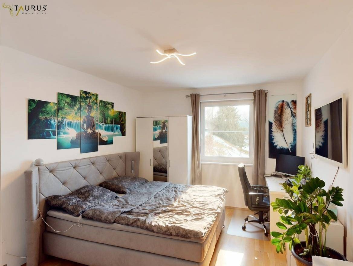 Gemütliches Schlafzimmer mit Doppelbett, Schreibtisch und Blick ins Grüne.