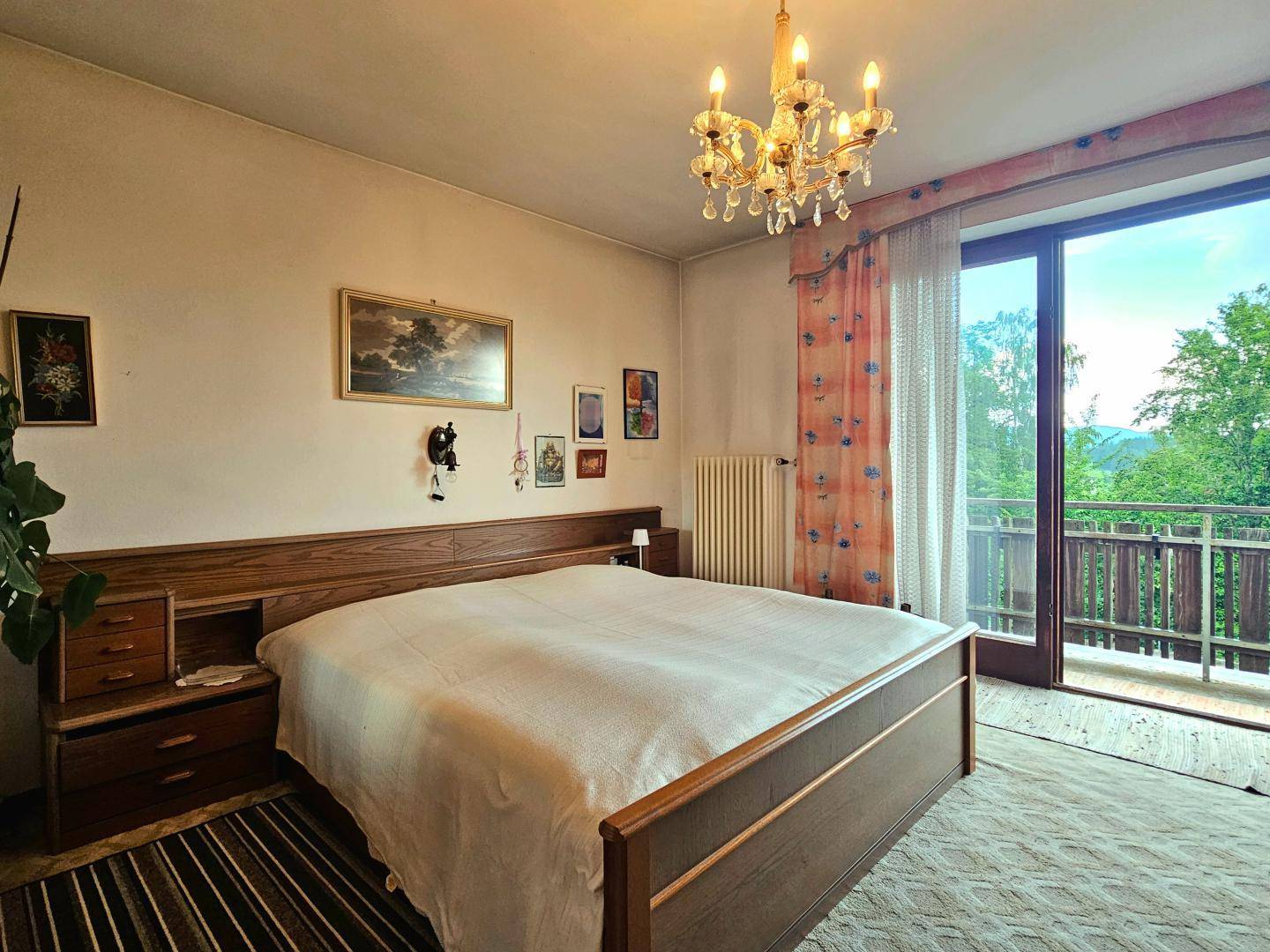 Schlafzimmer mit Doppelbett, Teppichboden und direktem Zugang zu einem Balkon.