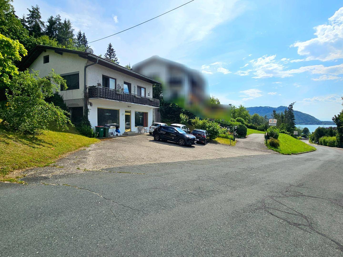 Außenansicht des Gebäudes mit Parkplätzen und Blick auf die umliegende grüne Landschaft.