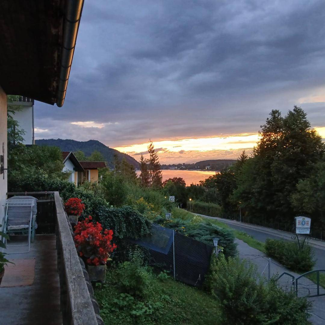Abendlicher Blick vom Balkon auf den See und die malerische Landschaft bei Dämmerung.