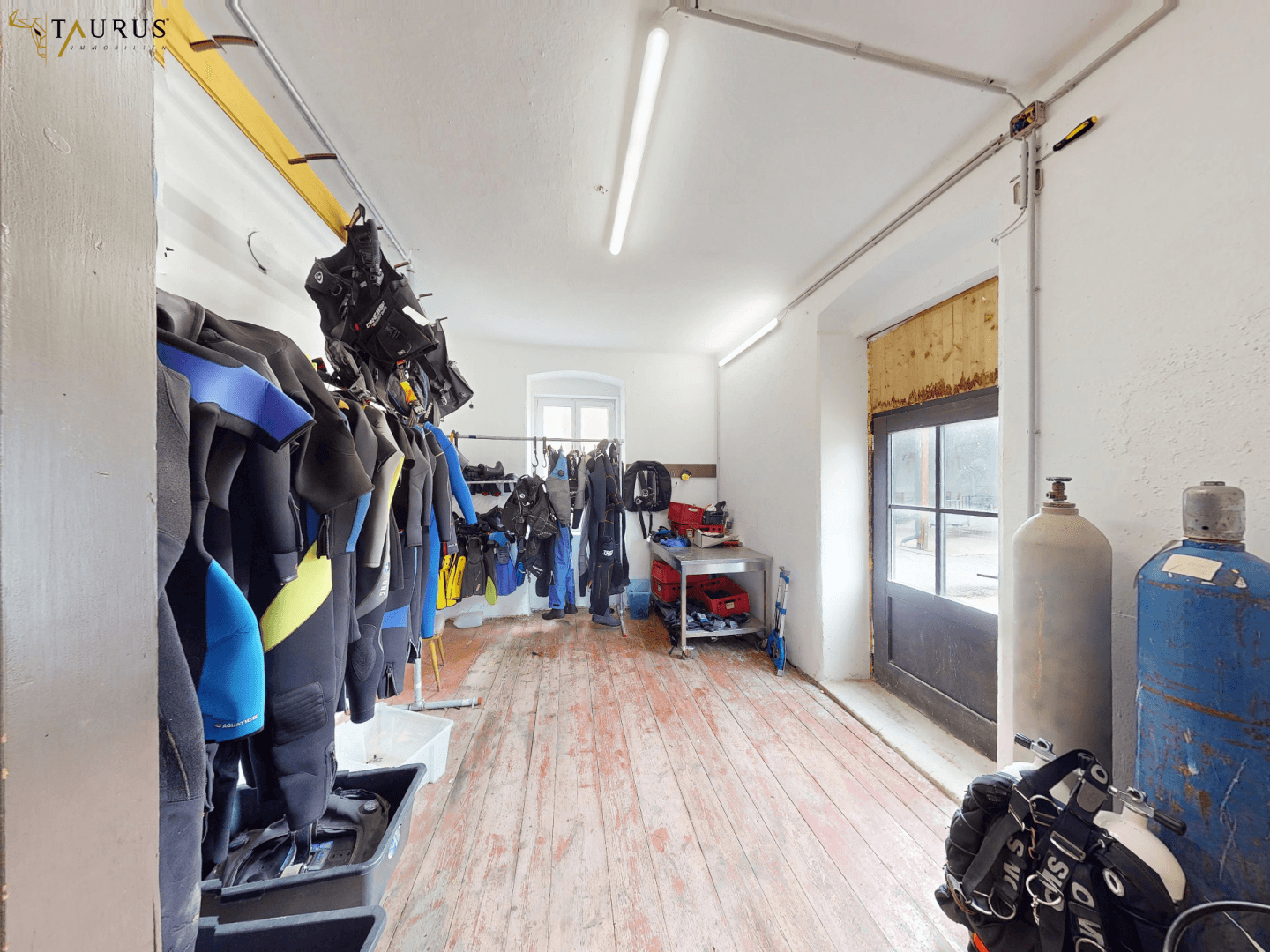 Lagerraum mit Holzboden und Tauchausrüstung, geeignet für Sport- oder Hobbybedarf.