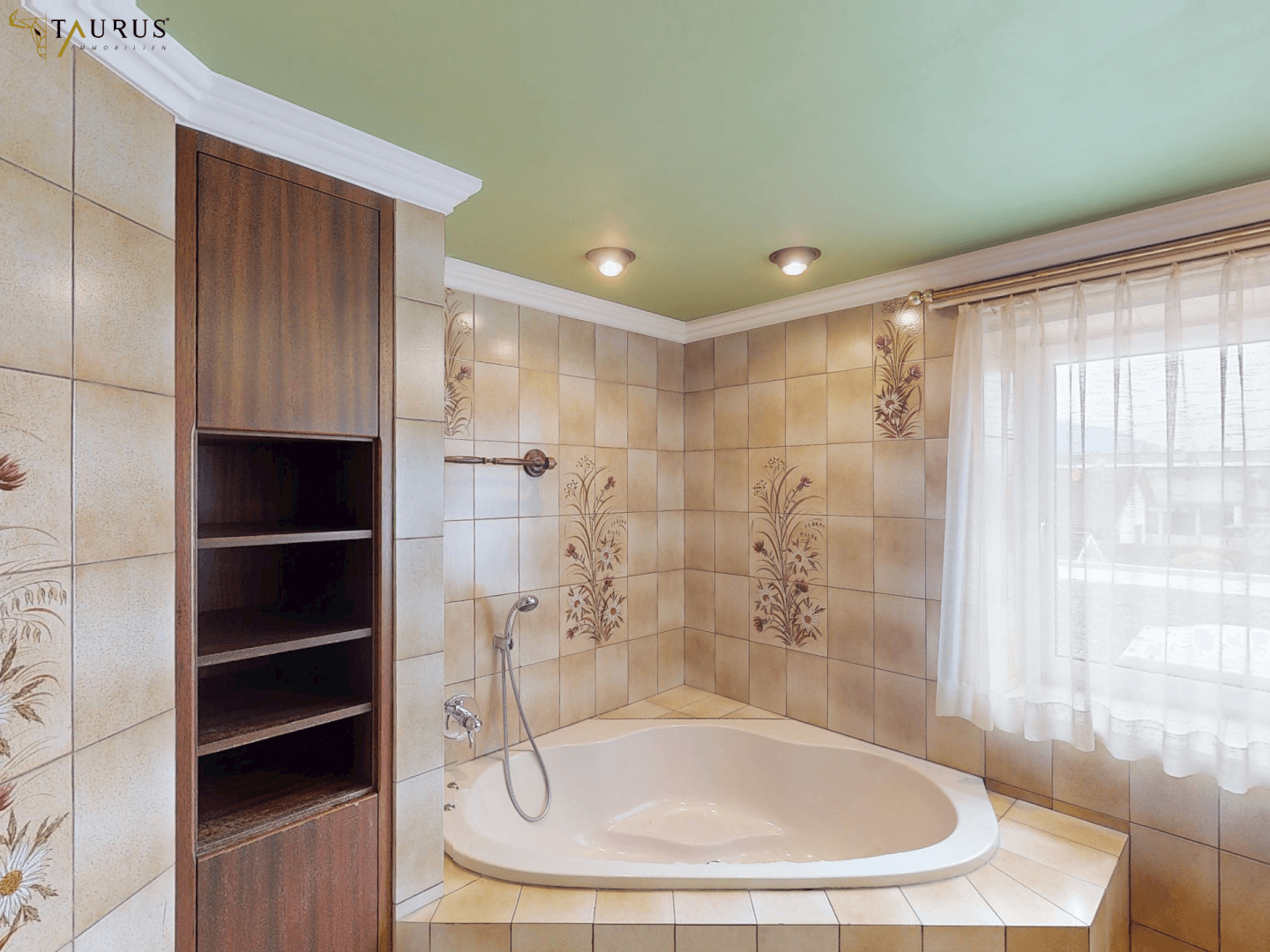 Badezimmer mit Eckbadewanne, gemusterten Fliesen und einem Fenster für Tageslicht.