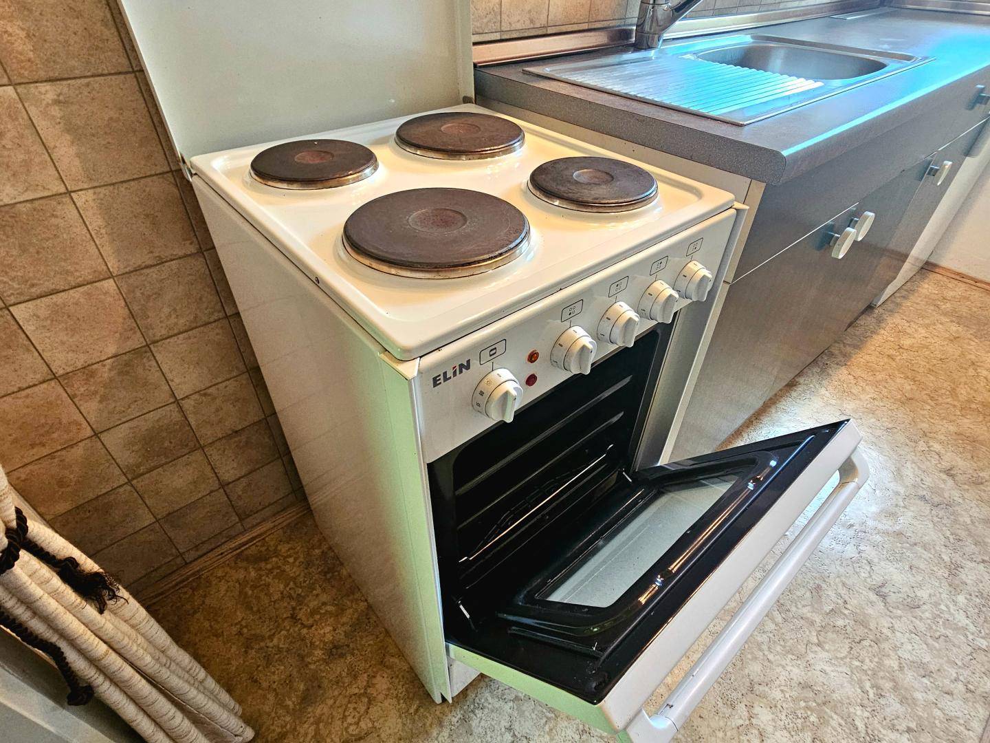 Freistehender Elektroherd mit vier Kochplatten und Backofen in der Küche.