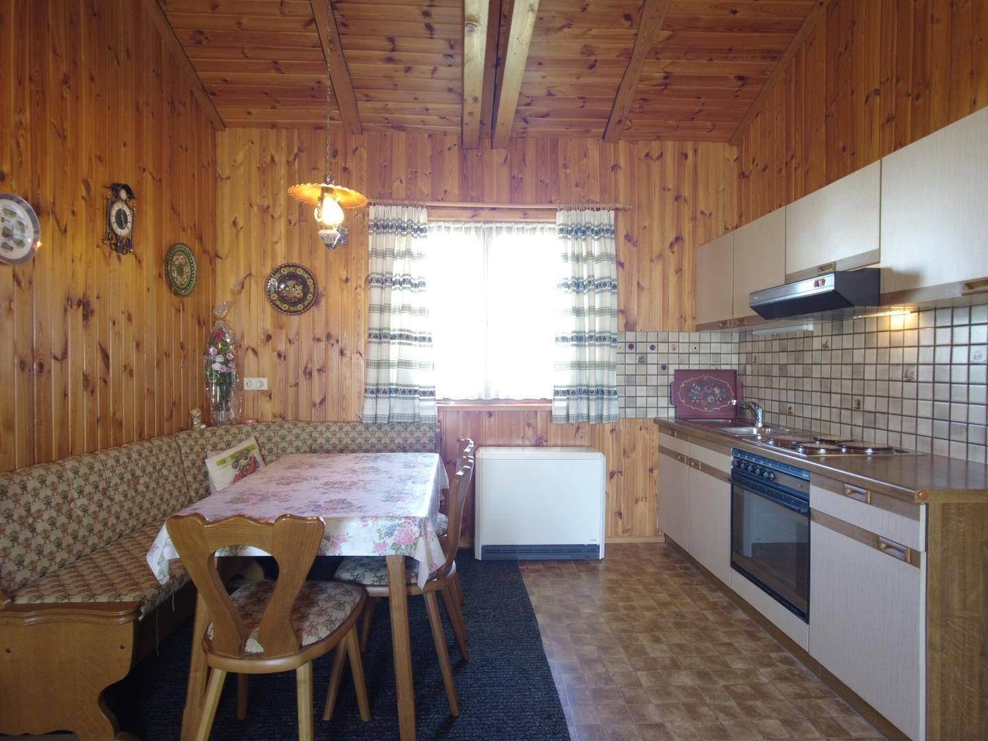 Gemütliche Küche mit Essecke, Holzvertäfelung und traditionellen Einbaumöbeln.