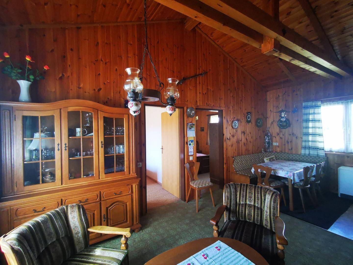 Geräumiger Wohn-Essbereich mit viel Holz, traditionellen Möbeln und gemütlicher Atmosphäre.